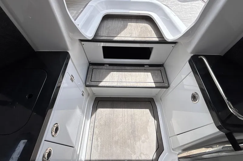 Slide: The Image of Interior view of 2026 Monterey Elite 27 OB boat, featuring sleek design and storage compartments. - 53