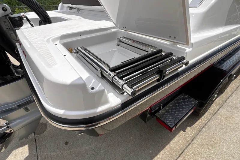Slide: The Image of 2026 Monterey Elite 27 OB boat with open storage compartment and metal components. - 58