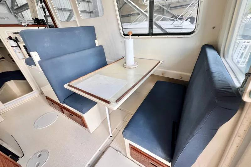Slide: The Image of 2001 Rosborough RF-246 Sedan Cruiser interior with blue cushioned seating and dining table. - 10