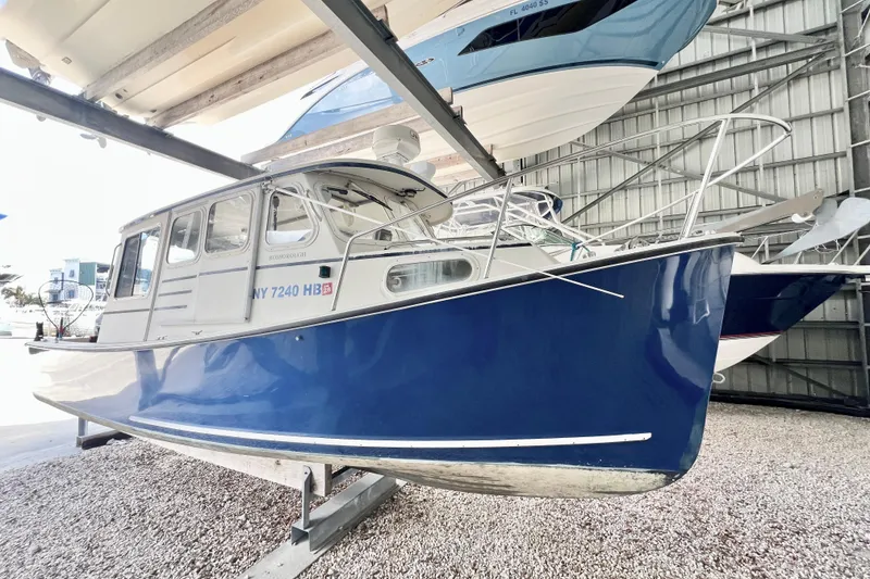 Slide: The Image of 2001 Rosborough RF-246 Sedan Cruiser in storage, blue hull, docked indoors. - 2
