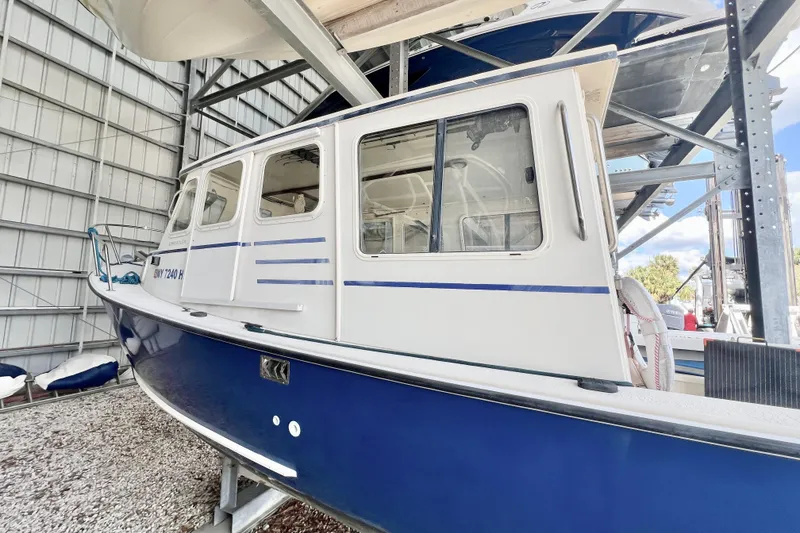 Slide: The Image of 2001 Rosborough RF-246 Sedan Cruiser in storage, featuring blue and white exterior. - 4