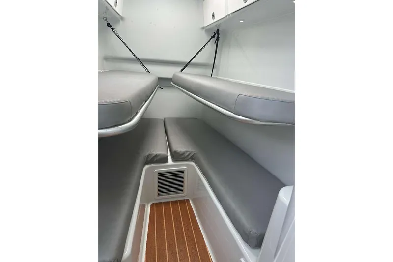 Slide: The Image of 2014 Yellowfin 42 Offshore cabin interior with gray cushioned bunks and wood flooring. - 17