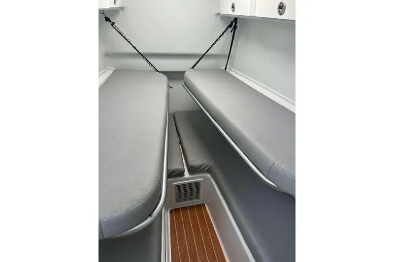 Slide: The Image of 2014 Yellowfin 42 Offshore cabin interior with gray seating and wooden flooring. - 18