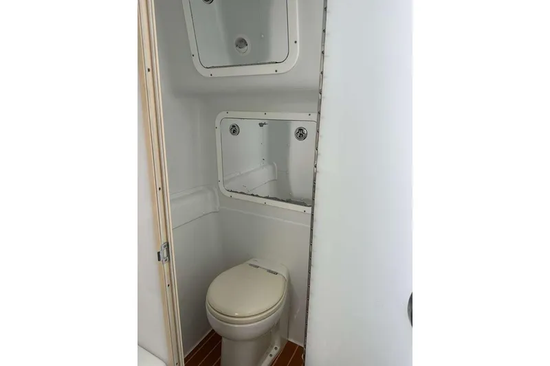 Slide: The Image of 2014 Yellowfin 42 Offshore boat bathroom with toilet and storage compartments. - 20