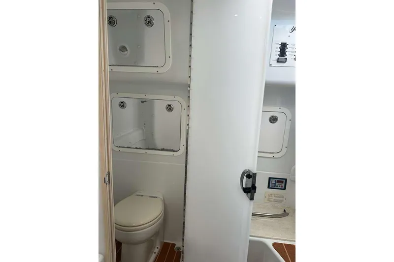 Slide: The Image of 2014 Yellowfin 42 Offshore boat bathroom with toilet and storage compartments. - 21