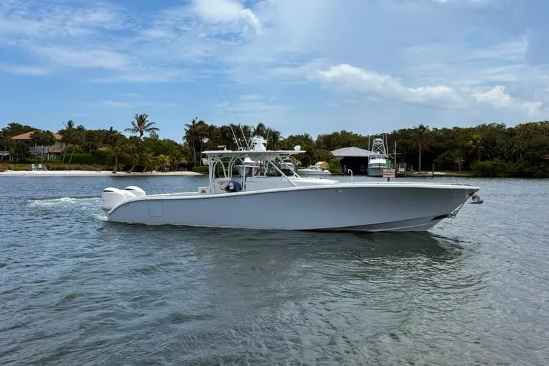 Slide: The Image of 2014 Yellowfin 42 Offshore boat cruising near a tropical shoreline. - 22