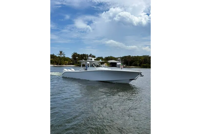 Slide: The Image of 2014 Yellowfin 42 Offshore boat cruising on a scenic waterway under a partly cloudy sky. - 27