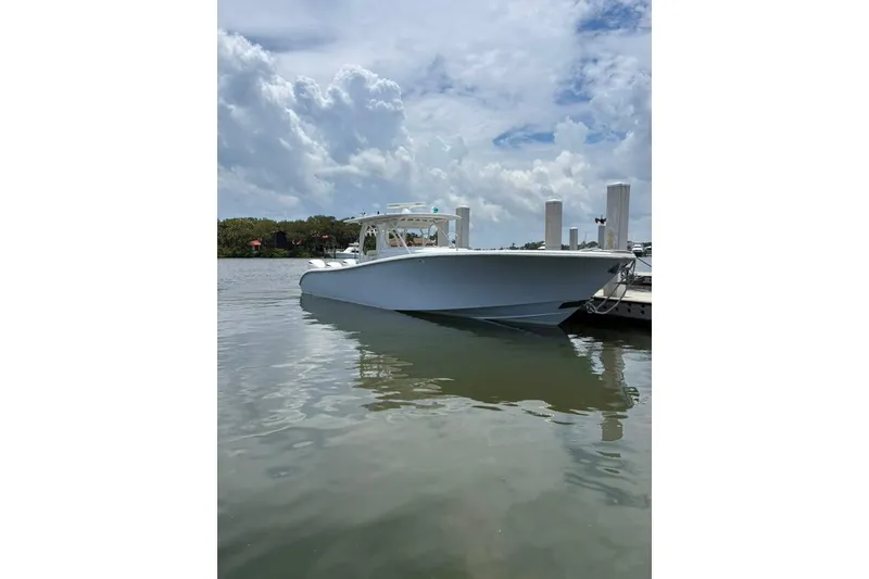 Slide: The Image of 2014 Yellowfin 42 Offshore boat docked on calm water under cloudy sky. - 28