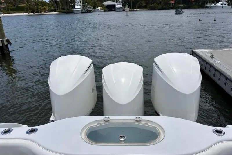Slide: The Image of 2014 Yellowfin 42 Offshore boat with triple outboard engines docked by the water. - 31