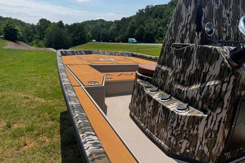 Slide: The Image of 2026 Avid 207 Recon boat with camouflage design on grassy landscape. - 1