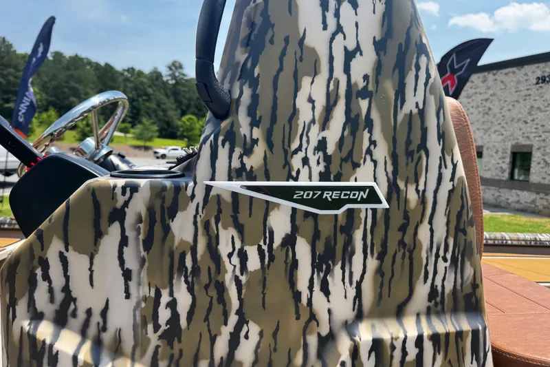 Slide: The Image of Camouflage-patterned Avid 207 Recon boat console, 2026 model, with steering wheel visible. - 19