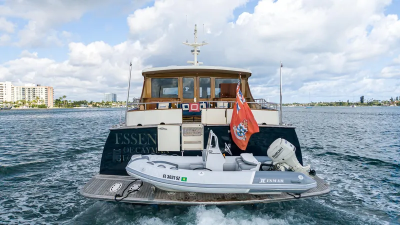 Slide: The Image of 2006 Vicem 85 Classic yacht with tender boat on water, displaying a red flag. - 18