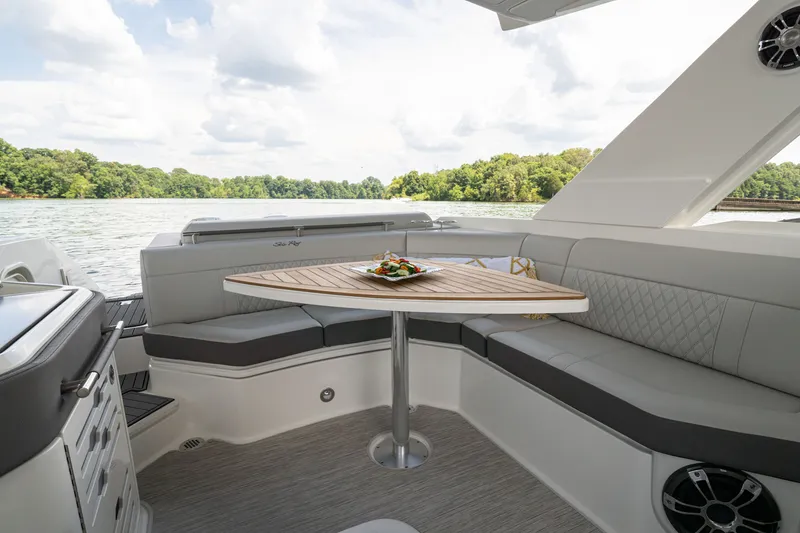 Slide: The Image of Interior of 2021 Sea Ray SLX 310 Outboard with table and seating area. - 15