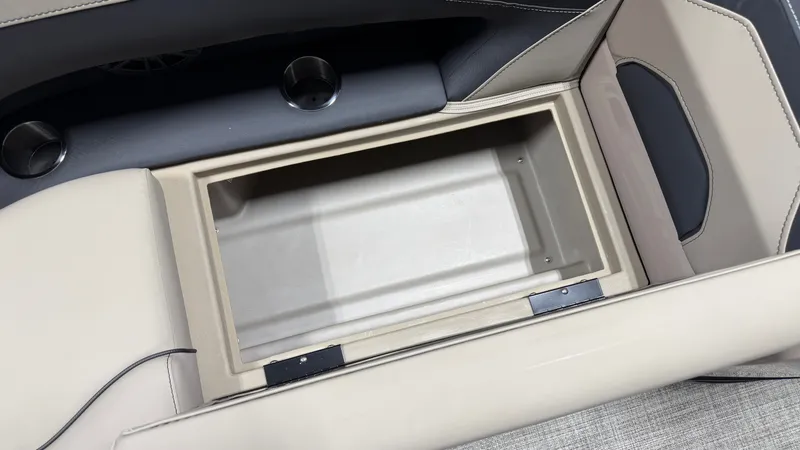 Slide: The Image of An open storage compartment in a boat with beige upholstery and cup holders. - 19