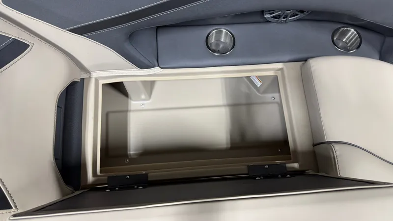 Slide: The Image of An open storage compartment on a Barletta ARIA22UC boat with two cup holders. - 28
