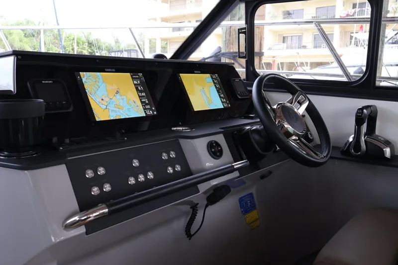Slide: The Image of 2024 Aquador 300 HT helm with dual navigation screens and modern controls. - 10