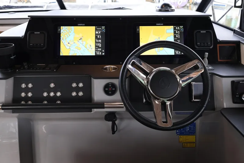 Slide: The Image of Cockpit of 2024 Aquador 300 HT boat with navigation screens and steering wheel. - 11