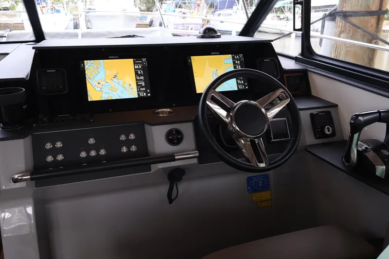 Slide: The Image of 2024 Aquador 300 HT boat cockpit with modern navigation displays and steering wheel. - 16