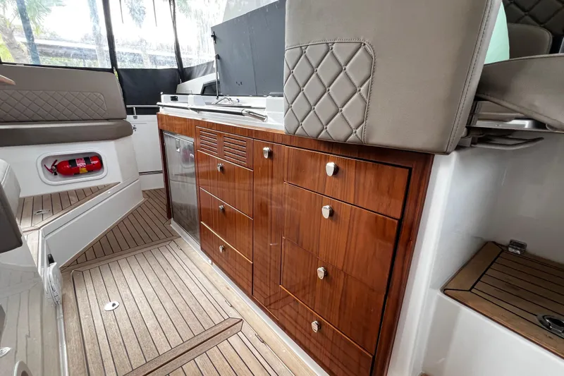 Slide: The Image of Interior of 2024 Aquador 300 HT boat featuring elegant wood cabinetry and seating. - 26