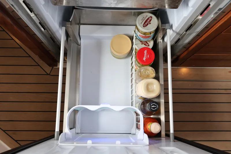 Slide: The Image of Refrigerator drawer on 2024 Aquador 300 HT yacht with condiments and wooden flooring. - 29