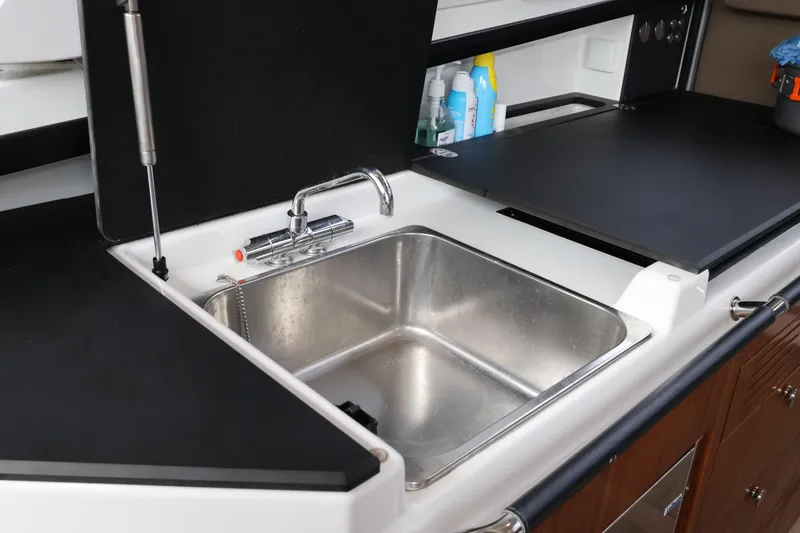 Slide: The Image of 2024 Aquador 300 HT yacht kitchen sink with modern faucet and storage. - 32
