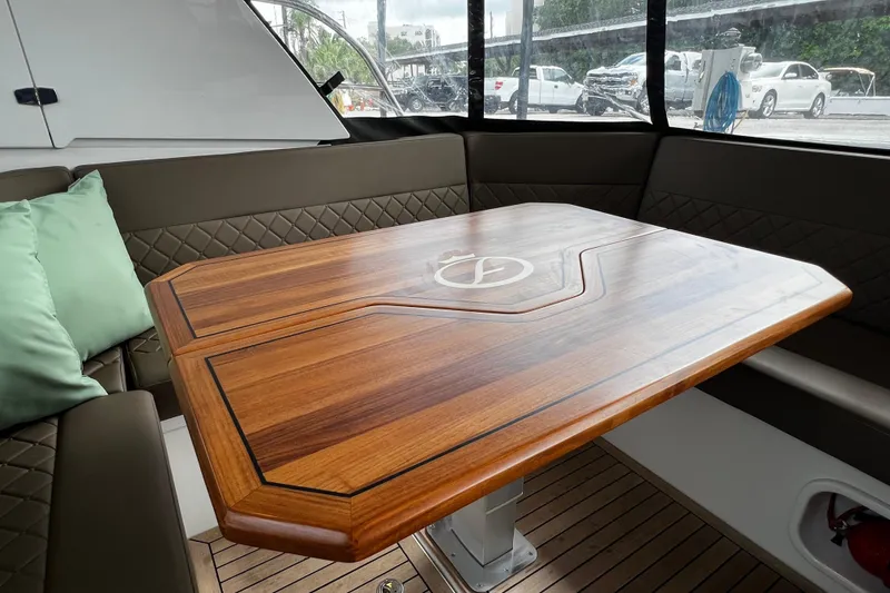 Slide: The Image of Luxurious interior of 2024 Aquador 300 HT yacht with elegant wooden table and cushioned seating. - 42