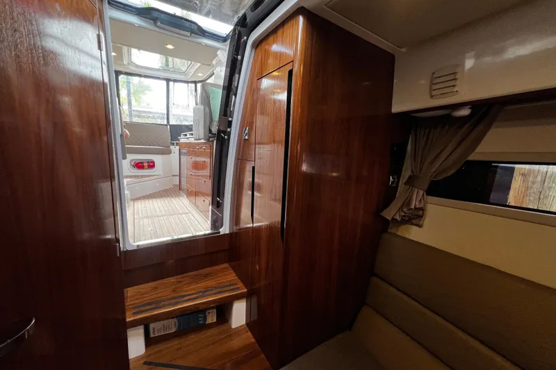 Slide: The Image of Interior view of 2024 Aquador 300 HT boat with wooden finishes and seating area. - 43