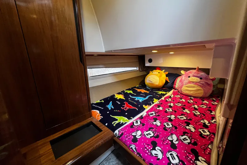 Slide: The Image of Cozy cabin interior of 2024 Aquador 300 HT with colorful bedding and plush toys. - 59