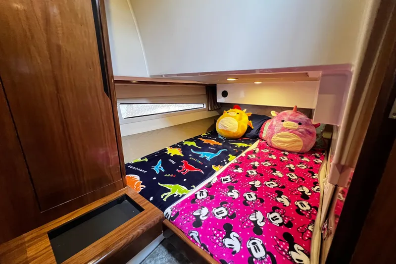 Slide: The Image of Cozy cabin in 2024 Aquador 300 HT with colorful bedding and plush toys. - 60
