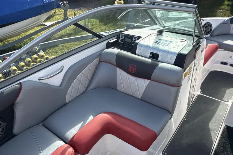 Slide: The Image of 2012 MasterCraft X-15 boat interior with red and gray seating, dashboard, and cup holders. - 5