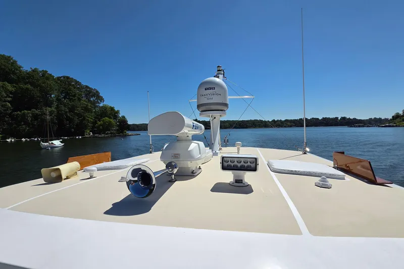 Slide: The Image of 2003 Grand Banks 49 Eastbay HX yacht deck with radar, cruising on a serene lake. - 14