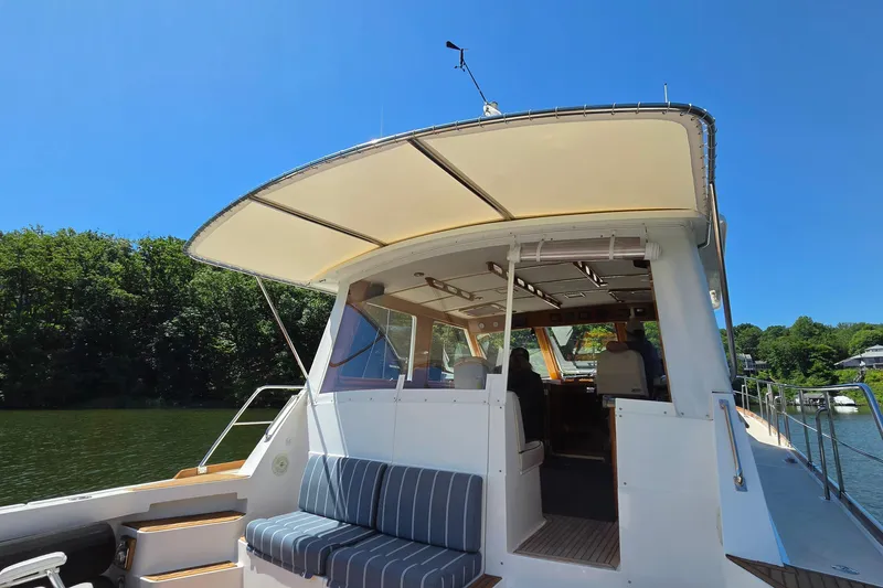 Slide: The Image of 2003 Grand Banks 49 Eastbay HX yacht with canopy, docked on a sunny day. - 16