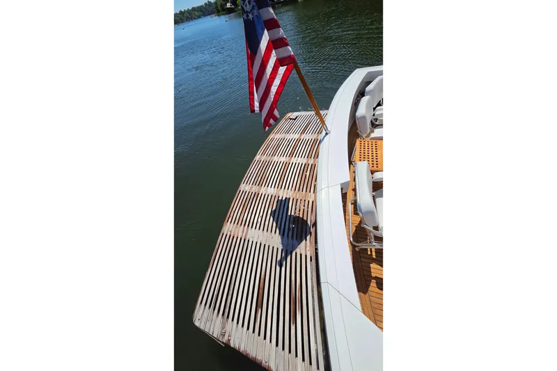 Slide: The Image of 2003 Grand Banks 49 Eastbay HX yacht with American flag on wooden deck. - 17