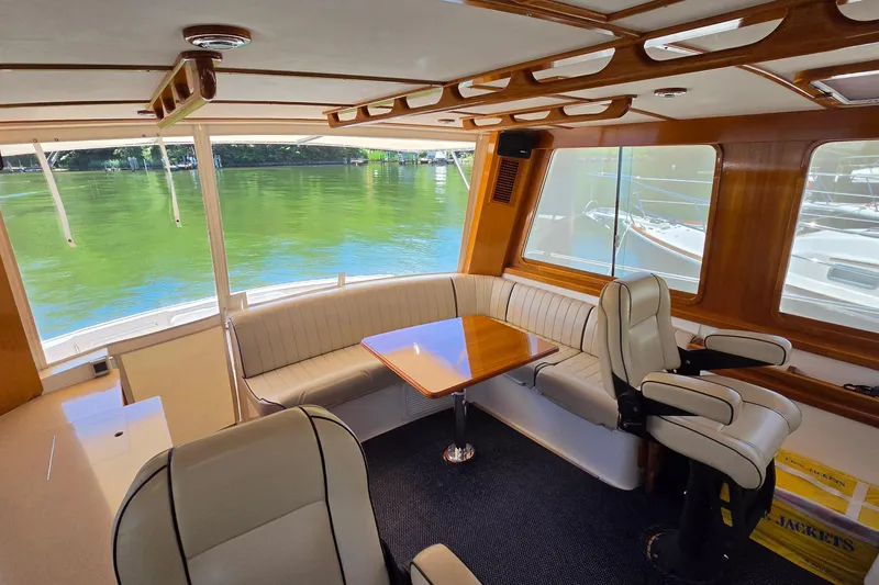 Slide: The Image of Luxurious 2003 Grand Banks 49 Eastbay HX yacht interior with elegant seating and scenic water views. - 26