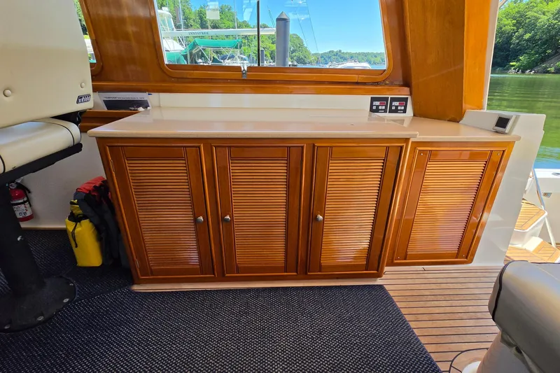 Slide: The Image of Interior of 2003 Grand Banks 49 Eastbay HX with wooden cabinetry and scenic window view. - 28