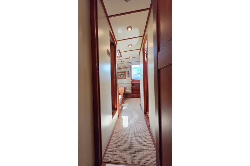 Slide: The Image of Interior hallway of 2003 Grand Banks 49 Eastbay HX yacht, featuring wood paneling and carpet. - 39