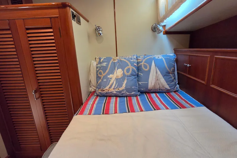 Slide: The Image of Cozy cabin bed with nautical-themed pillows on 2003 Grand Banks 49 Eastbay HX yacht. - 40