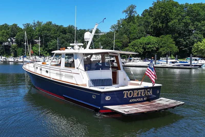 Slide: The Image of 2003 Grand Banks 49 Eastbay HX yacht docked in a serene marina setting. - 5