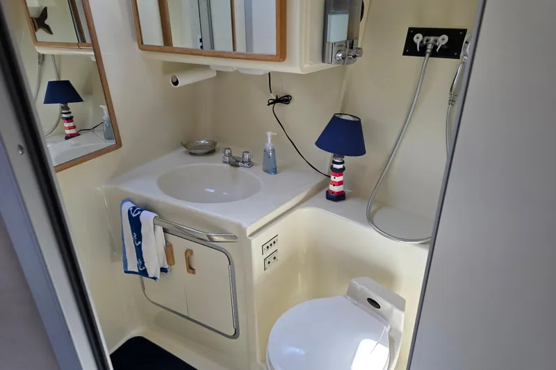 Slide: The Image of Bathroom interior of 1994 Sea Ray 370 Express Cruiser with sink, mirror, and nautical decor. - 19