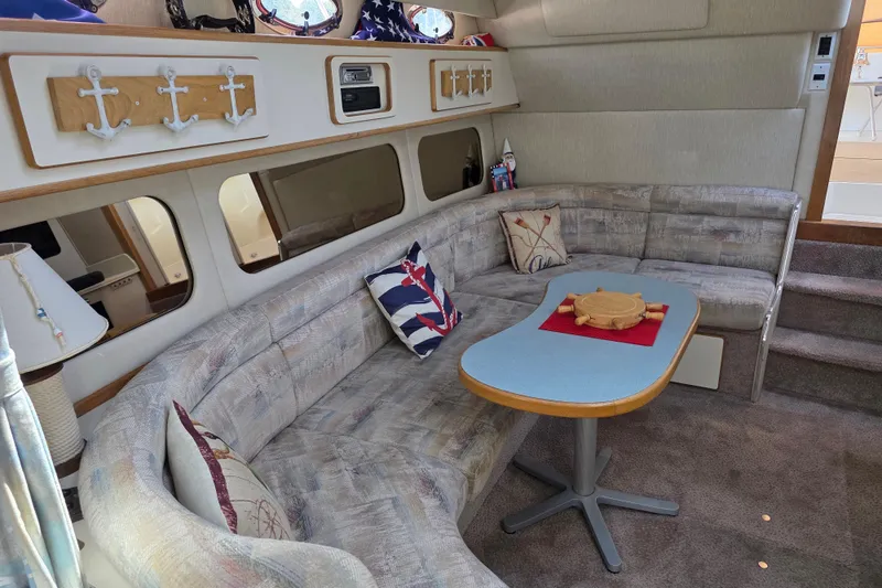 Slide: The Image of Interior of 1994 Sea Ray 370 Express Cruiser with nautical-themed decor and cozy seating area. - 21