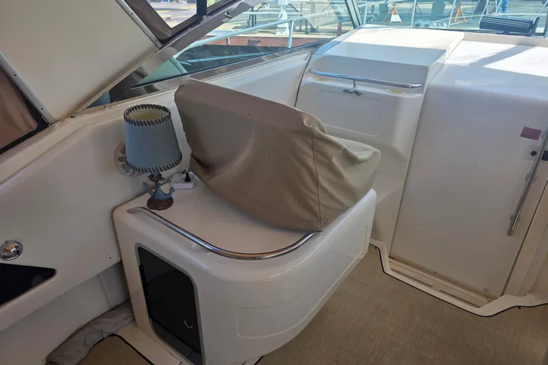 Slide: The Image of 1994 Sea Ray 370 Express Cruiser interior with covered seating and nautical decor. - 6