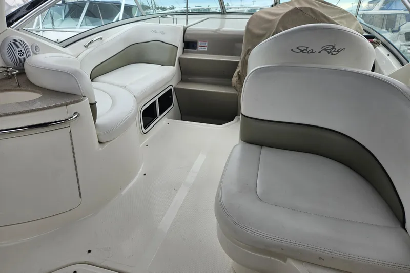 Slide: The Image of Interior of a 2007 Sea Ray 270 Sundancer boat with white seating and helm area. - 8