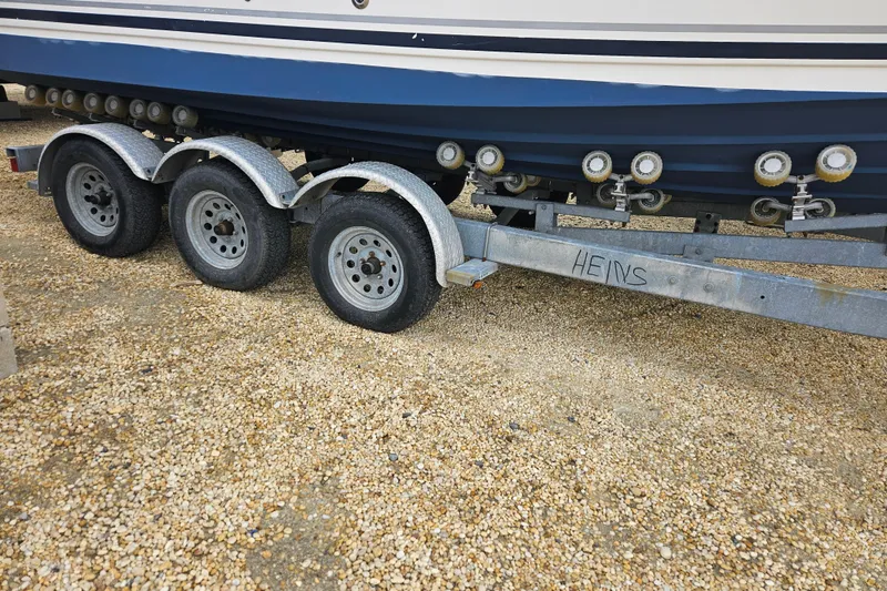 Slide: The Image of Triple-axle trailer with a 2007 Sea Ray 270 Sundancer boat on gravel. - 9
