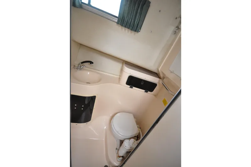 Slide: The Image of Compact bathroom in 1997 Grady-White Marlin 300 boat, featuring sink and toilet. - 12