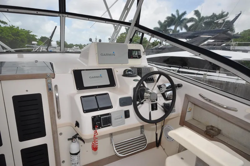 Slide: The Image of 1997 Grady-White Marlin 300 boat cockpit with Garmin navigation system and steering wheel. - 13
