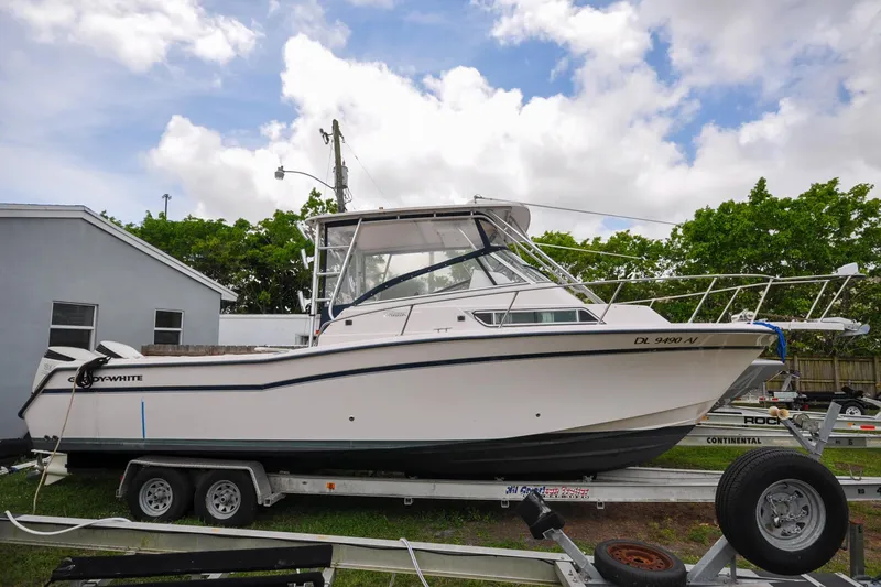 Slide: The Image of 1997 Grady-White Marlin 300 boat on trailer, parked outdoors under cloudy sky. - 18