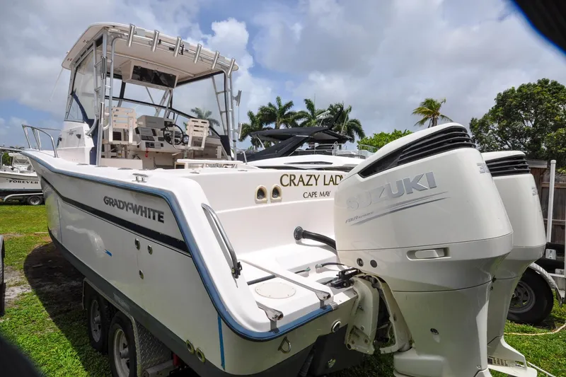 Slide: The Image of 1997 Grady-White Marlin 300 boat with Suzuki engines, parked on grass. - 19