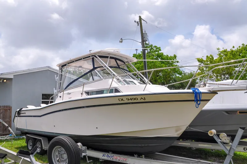 Slide: The Image of 1997 Grady-White Marlin 300 boat on trailer, parked outdoors under cloudy sky. - 21
