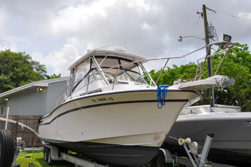 Slide: The Image of 1997 Grady-White Marlin 300 boat on trailer, parked outdoors under cloudy sky. - 22
