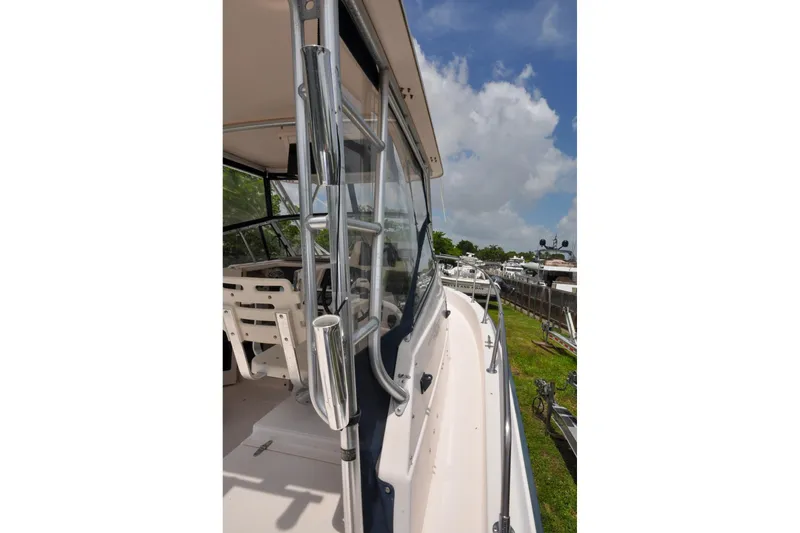 Slide: The Image of 1997 Grady-White Marlin 300 boat deck with clear skies and marina view. - 24